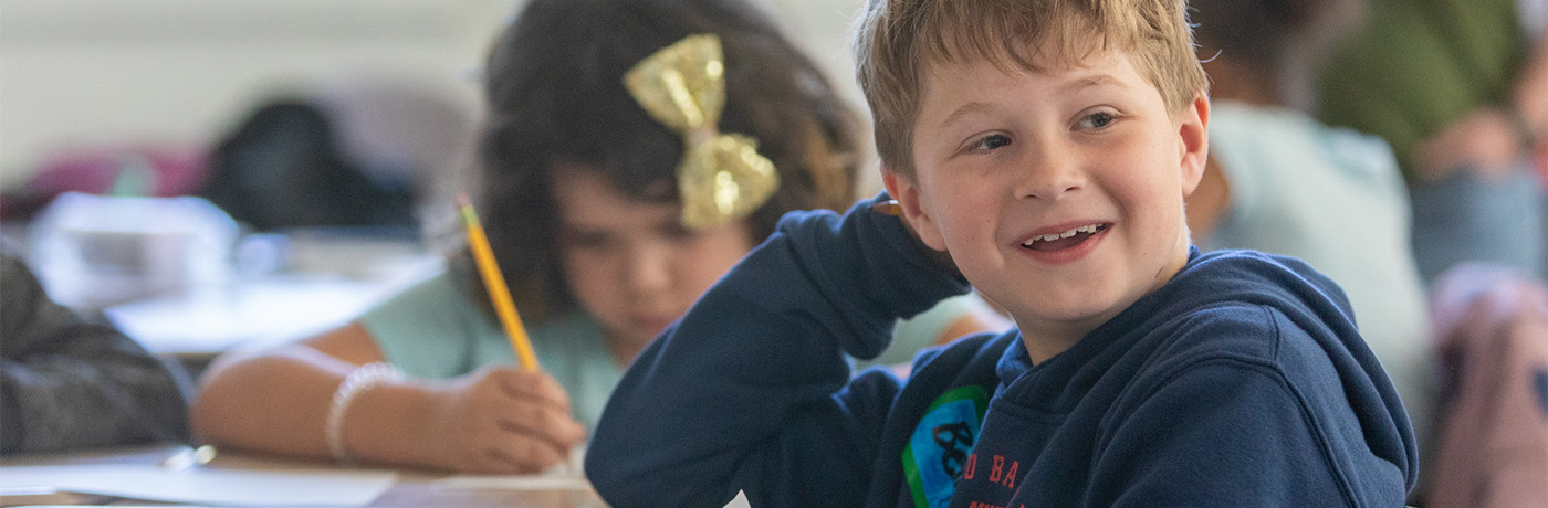 student smiling at his desk